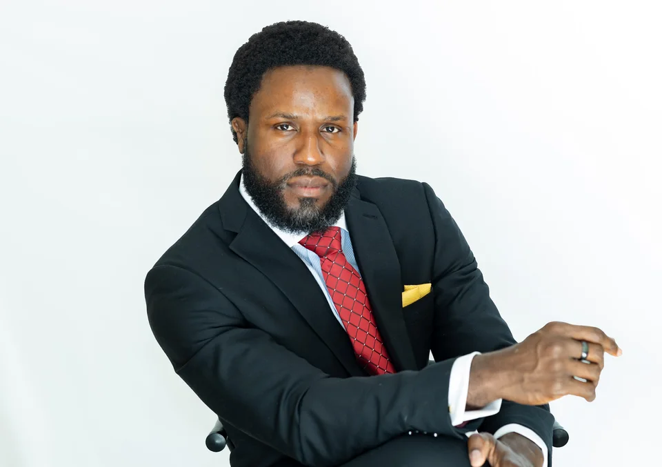 Seated business portrait in a suit and red tie