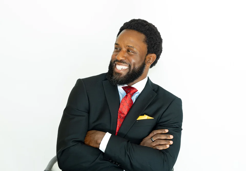 Smiling professional in a dark suit and red tie