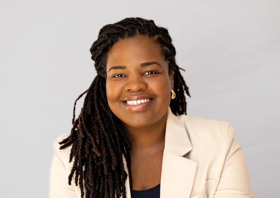 Smiling headshot in a cream blazer
